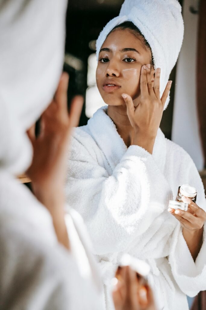 a woman doing her skin care routine applying a moisturizer